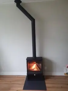 Charlton & Jenrick Fireline Woodtec 5 kW-XW extra breed 564 mm vooraanzicht brandend met pijp