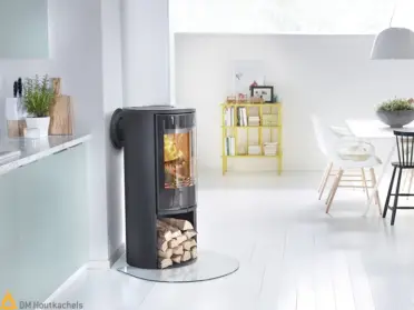 In de lichte woonkamer brandt de Contura 510G Style houtkachel, met zwarte afwerking, grote glazen deur en zicht op het vlammende vuur op glas.
