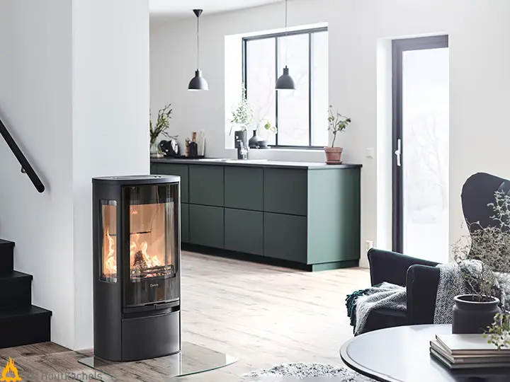 De Contura 856G Style staat in een lichte woonkamer en laat via de glazen zijwanden en deur helder zicht op de vlammen zien.