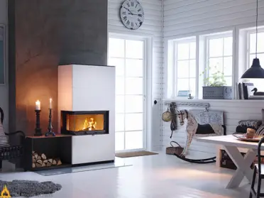 Een Contura i41A in zwart-witte afwerking brandt sfeervol in een lichte woonkamer met houten vloer, naast een nis voor hout en een grote klok.