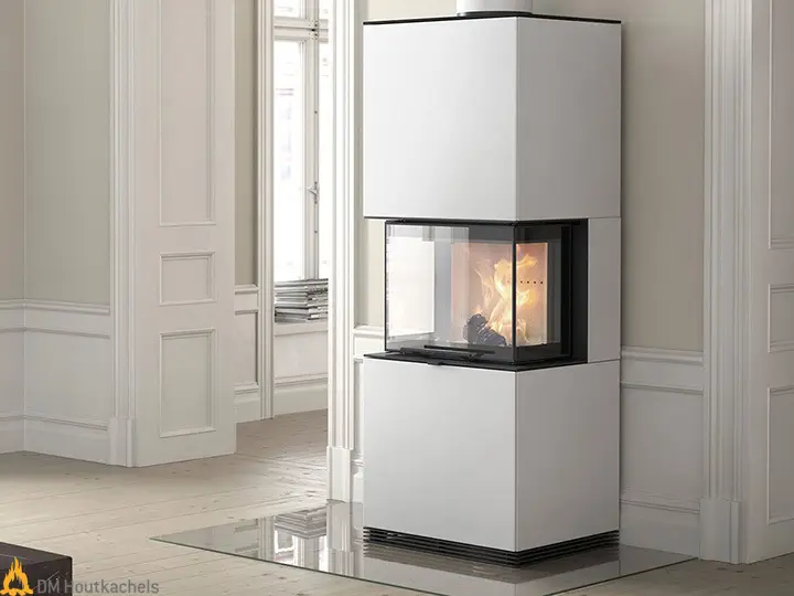De Contura i61 wit staal staat in een lichte kamer met een strak wit ombouwdeel, zwarte omlijsting en zichtbaar vlammenspel achter glas.