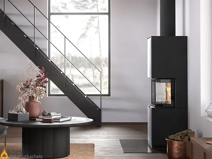 In een lichte woonkamer staat de Contura i61 zwart staal naast een trap, met zichtbaar vuur in de kachel en een strakke, moderne afwerking.