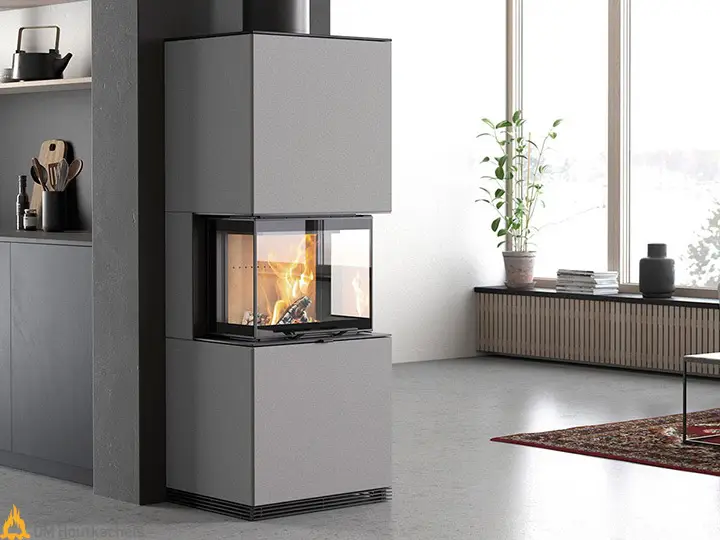 De grijze Contura i61AN brandt in een strak interieur met grote ramen, een plant op de vensterbank en warme vlammen achter het glas.