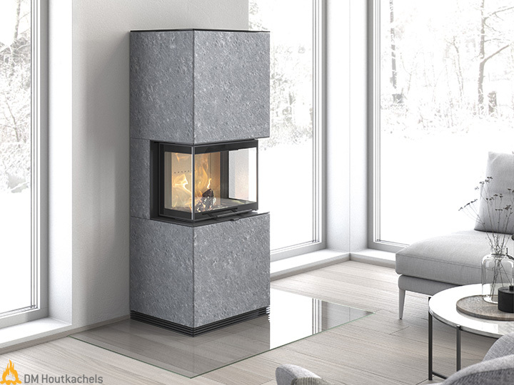 De Contura i61T staat in een lichte woonkamer als grijze speksteenkachel met een brandend haardvuur en grote ramen rondom.