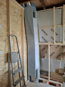 Dubbelwandig rookkanaal door 1e verdieping met de juiste afstanden tot brandbare materialen met omkokering van onbrandbare platen